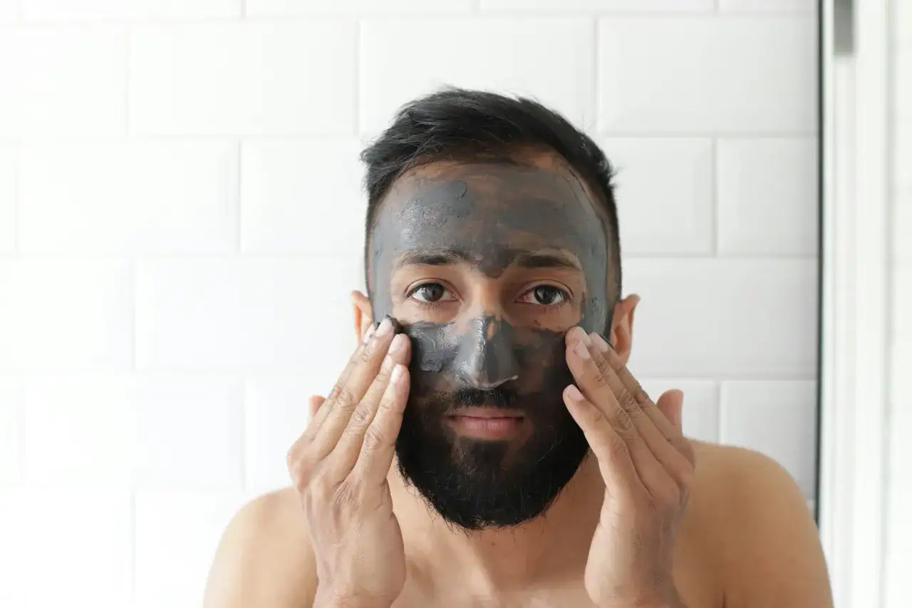 Un homme applique un masque &agrave; l'argile pour comment soigner une irritation cutan&eacute;e.