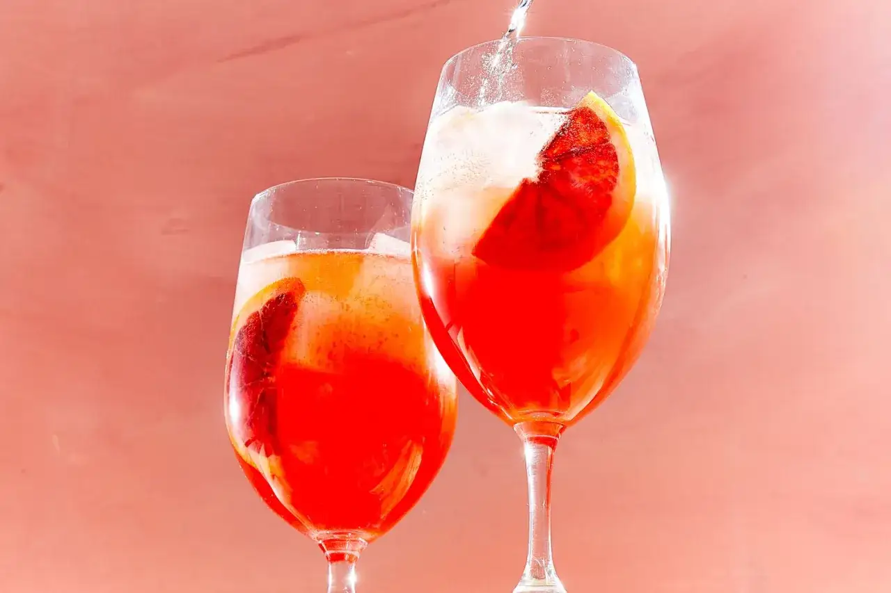 Zwei leuchtend rote Campari Cocktails mit Orangenscheiben und Eisw&uuml;rfeln, bereit zum Genie&szlig;en.