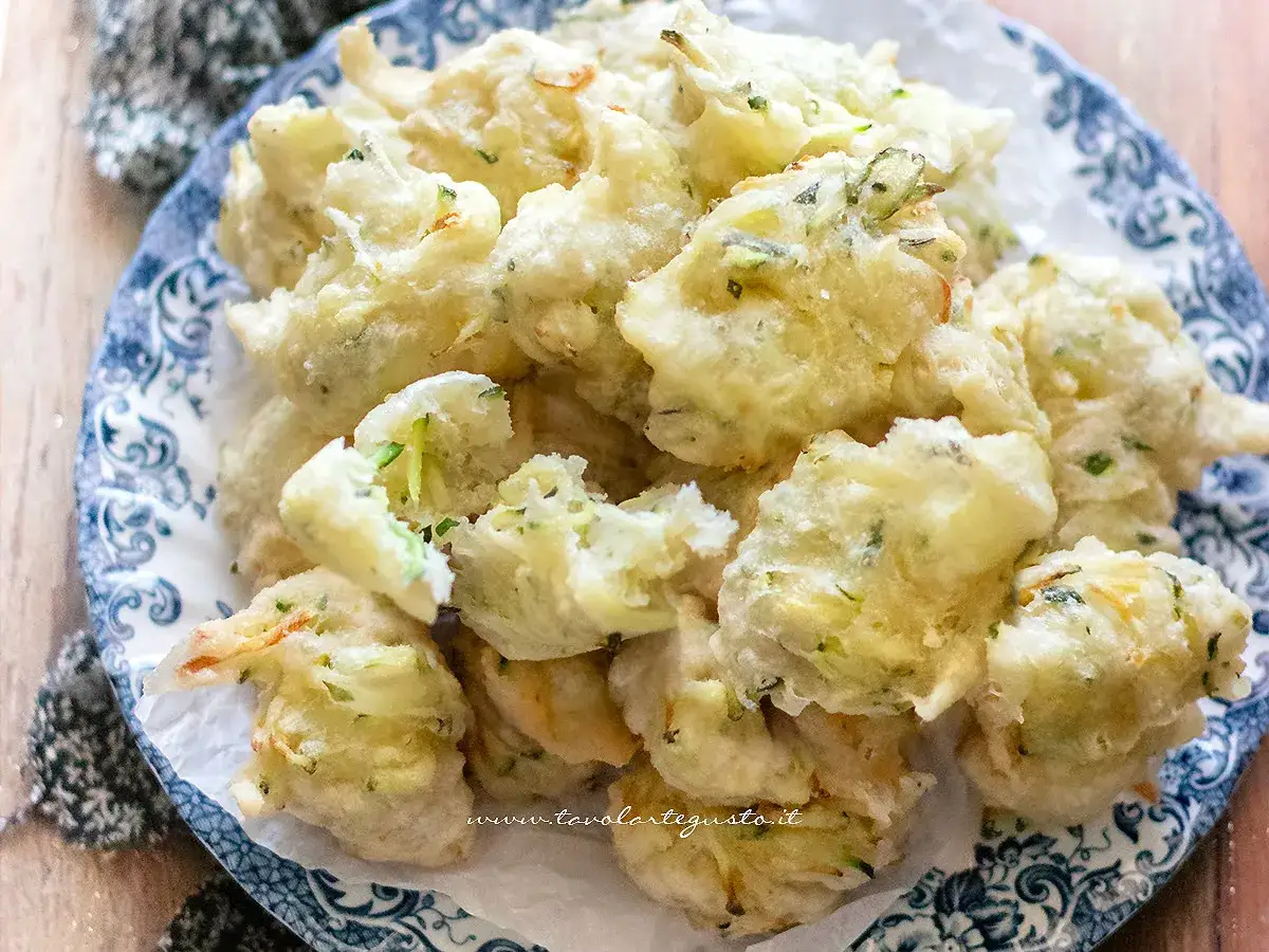 Frittelle di zucchine dolci, dorate e croccanti, servite su un piatto decorato. Un'esplosione di sapore!