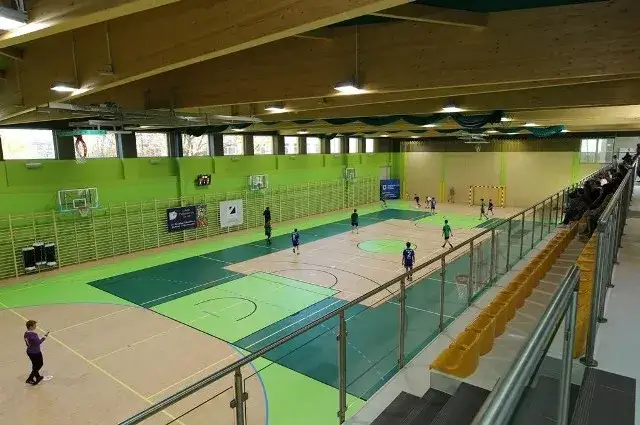Porównanie małej sali gimnastycznej i dużej hali sportowej z trybunami