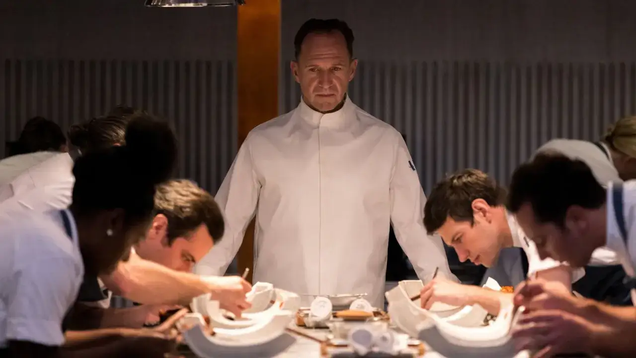 Chef severo osserva il suo team preparare meticolosamente ogni piatto per il dinner.
