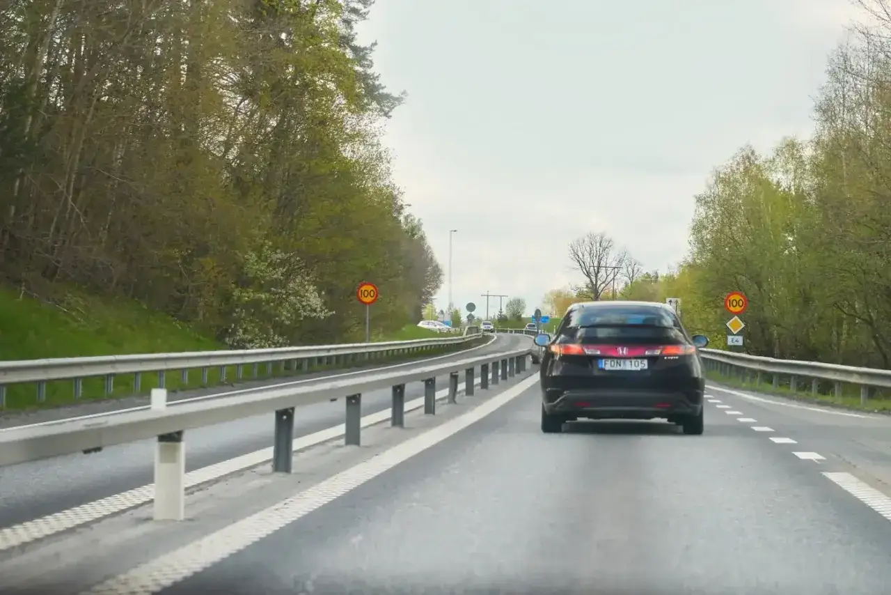 En mopedbil kör på en landsväg i Sverige. Hastighetsbegränsningen är 100 km/h.