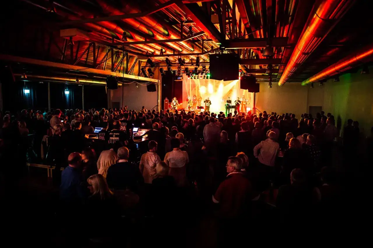 Konzert in Emsdetten mit Band auf der Bühne und vielen Zuschauern. Tolle Beleuchtung bei den Emsdetten Veranstaltungen.
