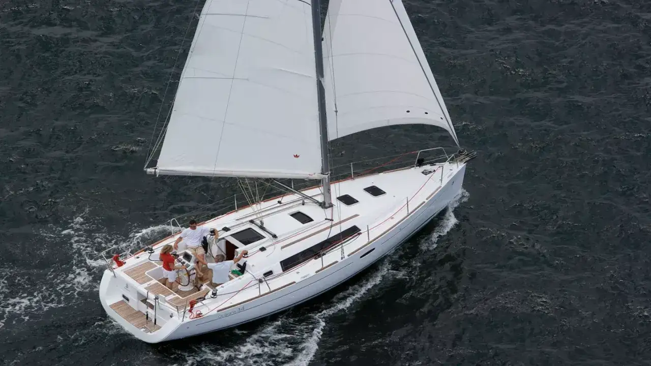 Un voilier Oceanis 34 navigue sur une mer agitée. Les avis sur ce bateau sont positifs, il offre une belle expérience de navigation.