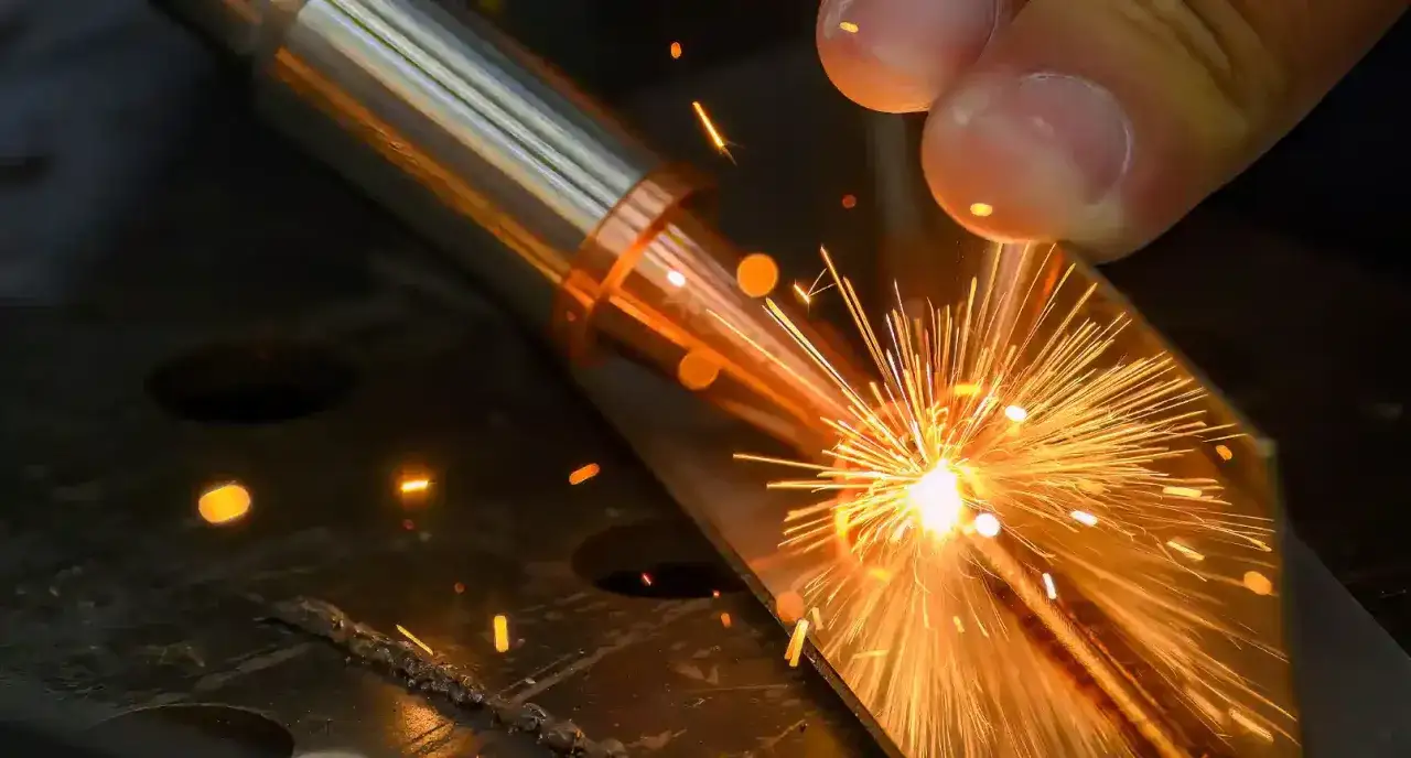 Precyzyjne laserowe spawanie metalu, iskry rozbłyskują w intensywnym świetle.