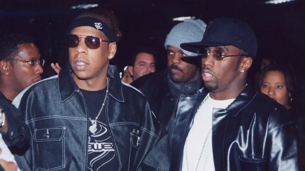 Jay-Z y P. Diddy, íconos del estilo Y2K, posan con gafas de sol y cadenas.