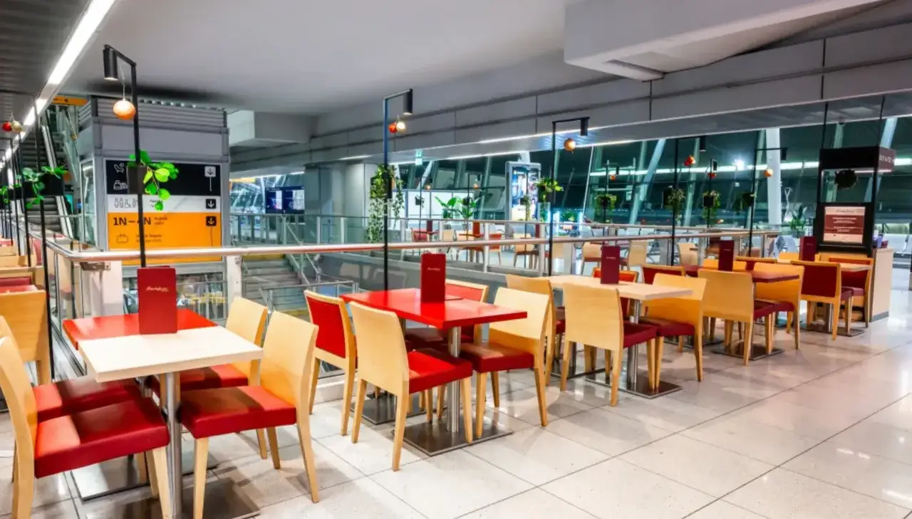 Wygodne stoliki i krzesła w restauracjach na lotnisku Chopina, idealne na posiłek przed podr&oacute;żą.