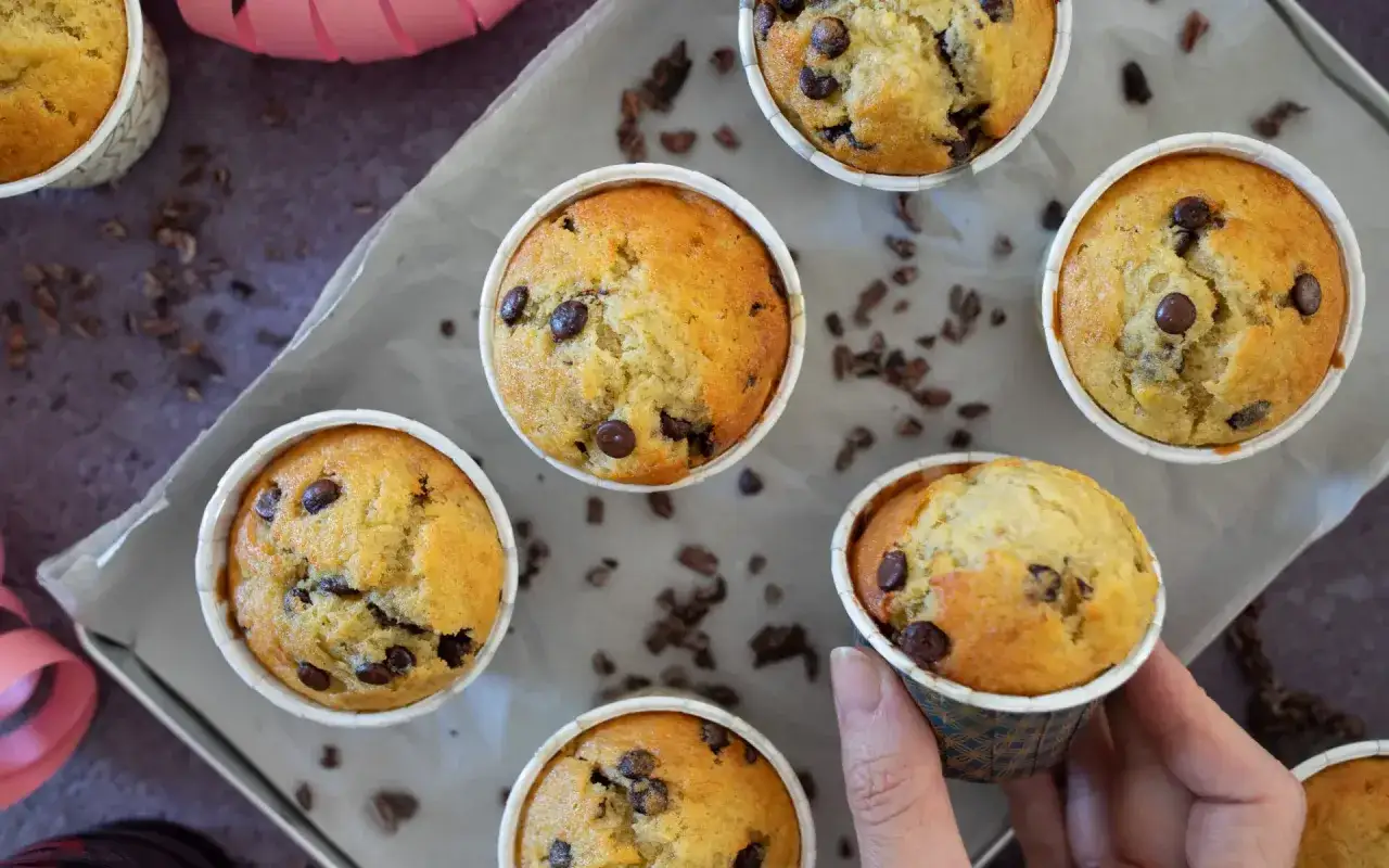 Leckere Bananen Muffins mit Schokostückchen, frisch gebacken und auf Backpapier arrangiert.