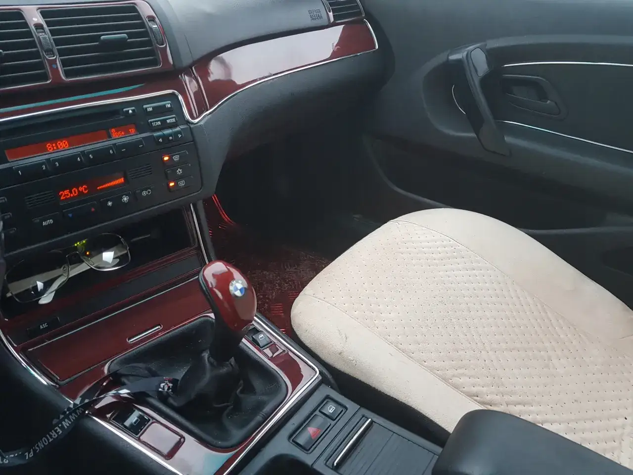 Wnętrze BMW E46 Coupe M Pakiet: jasna skórzana tapicerka, drewniane wstawki, dźwignia zmiany biegów i radio.