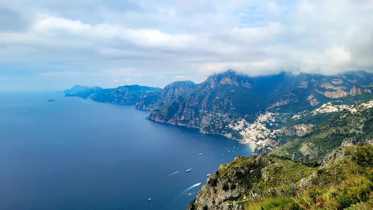 Vista mozzafiato dal Sentiero degli Dei: mare blu intenso, scogliere a picco e il bianco di Positano aggrappato alla montagna.