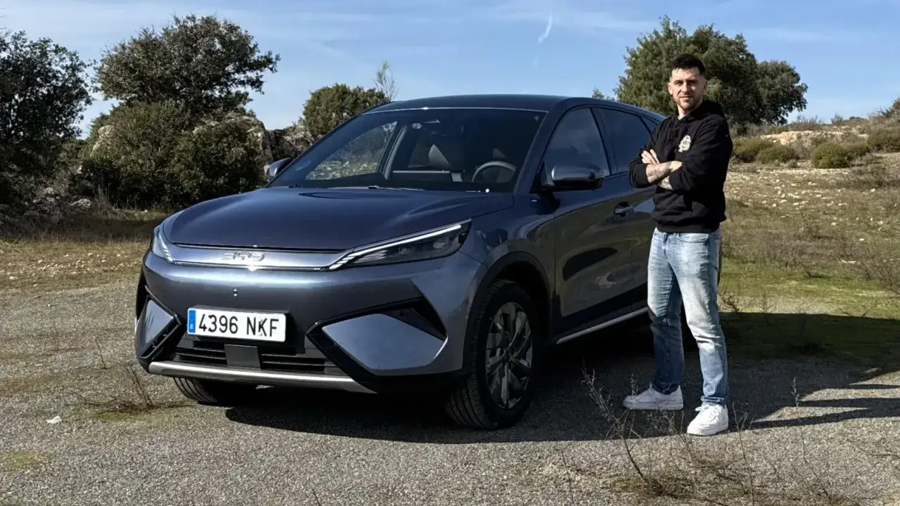 Hombre posa junto a un BYD Atto 3 en una prueba de manejo. El coche el&eacute;ctrico se ve moderno y elegante.