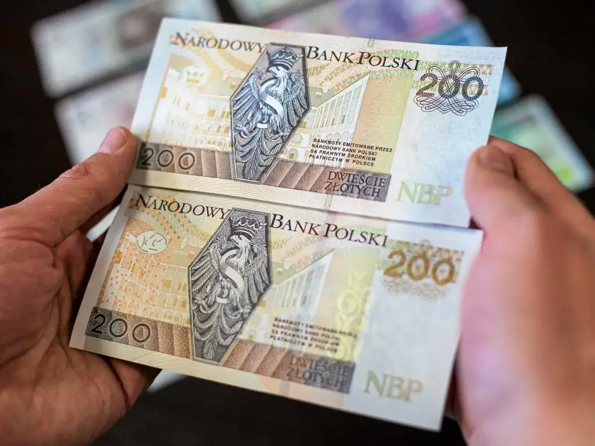 Dwie ręce trzymają dwa banknoty po 200 zł. Wiesz, gdzie wymienić uszkodzony banknot?