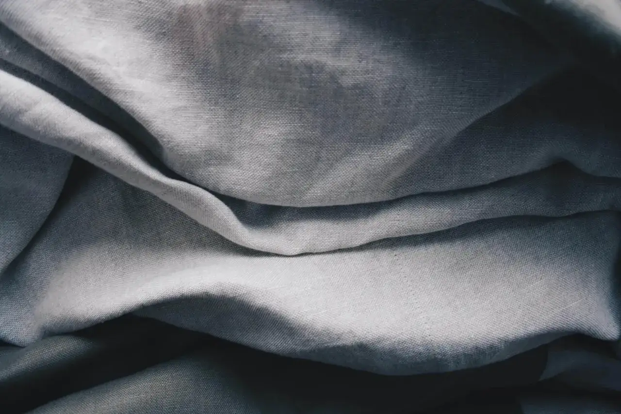 Grauer Stoff mit Falten, ideal f&uuml;r eine W&auml;sche bei 50&deg;C, da er aus 50% Baumwolle und 50% Polyester besteht.
