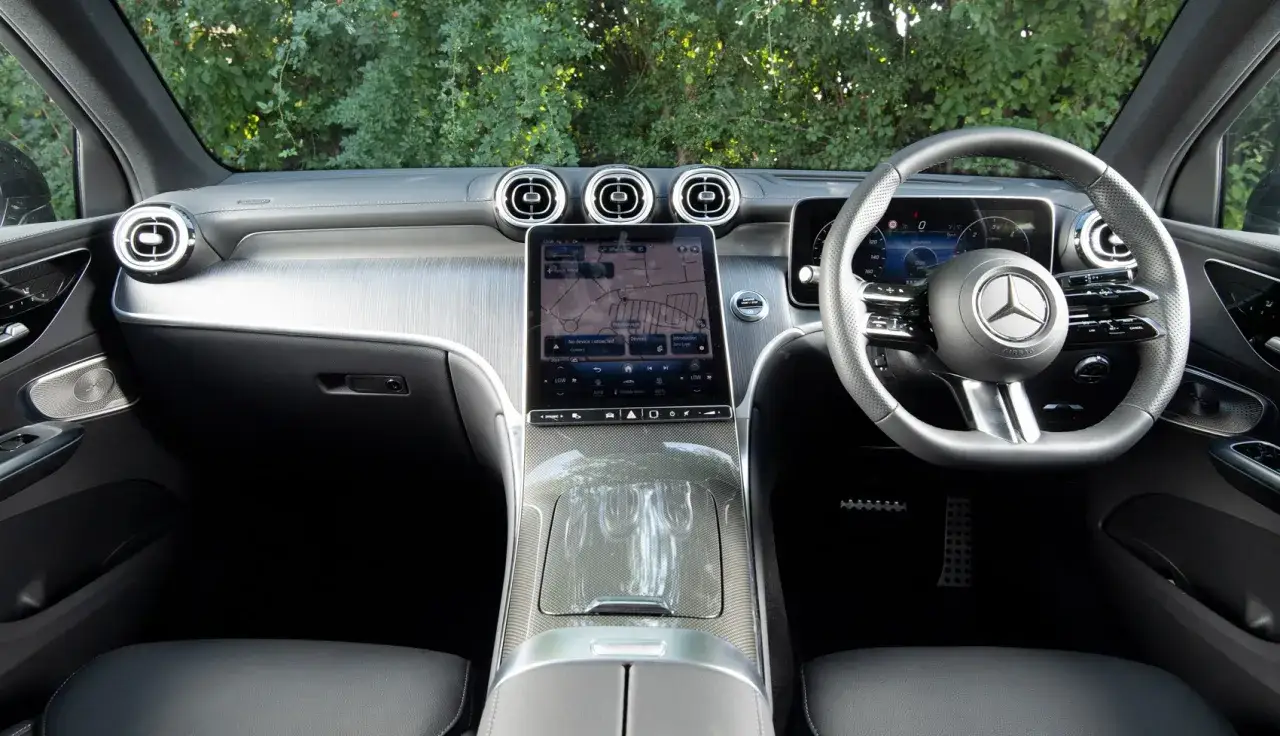 Wnętrze Mercedesa GLC 300d z ekranem nawigacji i kierownicą.