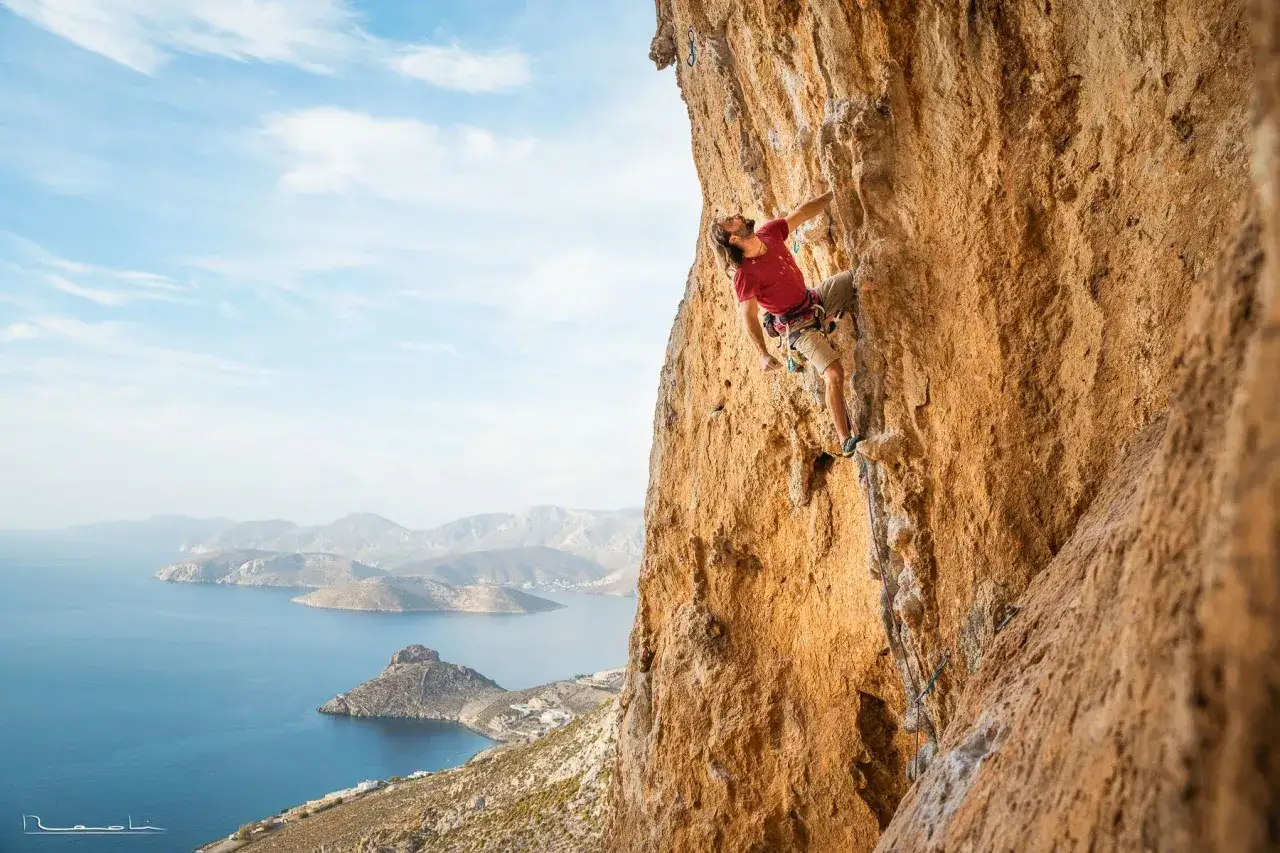 Wspinacz na skale na Kalymnos, z widokiem na morze i wyspy. Niesamowite **kalymnos wspinanie** w słońcu.