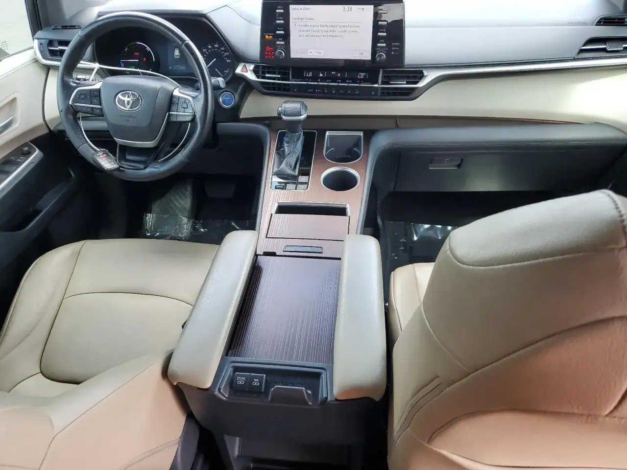 Wnętrze Toyoty Sienna 2025 z beżową skórzaną tapicerką, nowoczesnym panelem sterowania i ekranem multimedialnym.