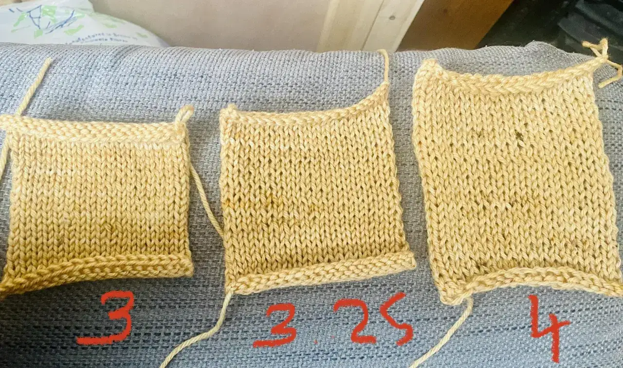 Tre stickade provlappar i ljusgult garn, märkta med siffrorna 3, 3.25 och 4.