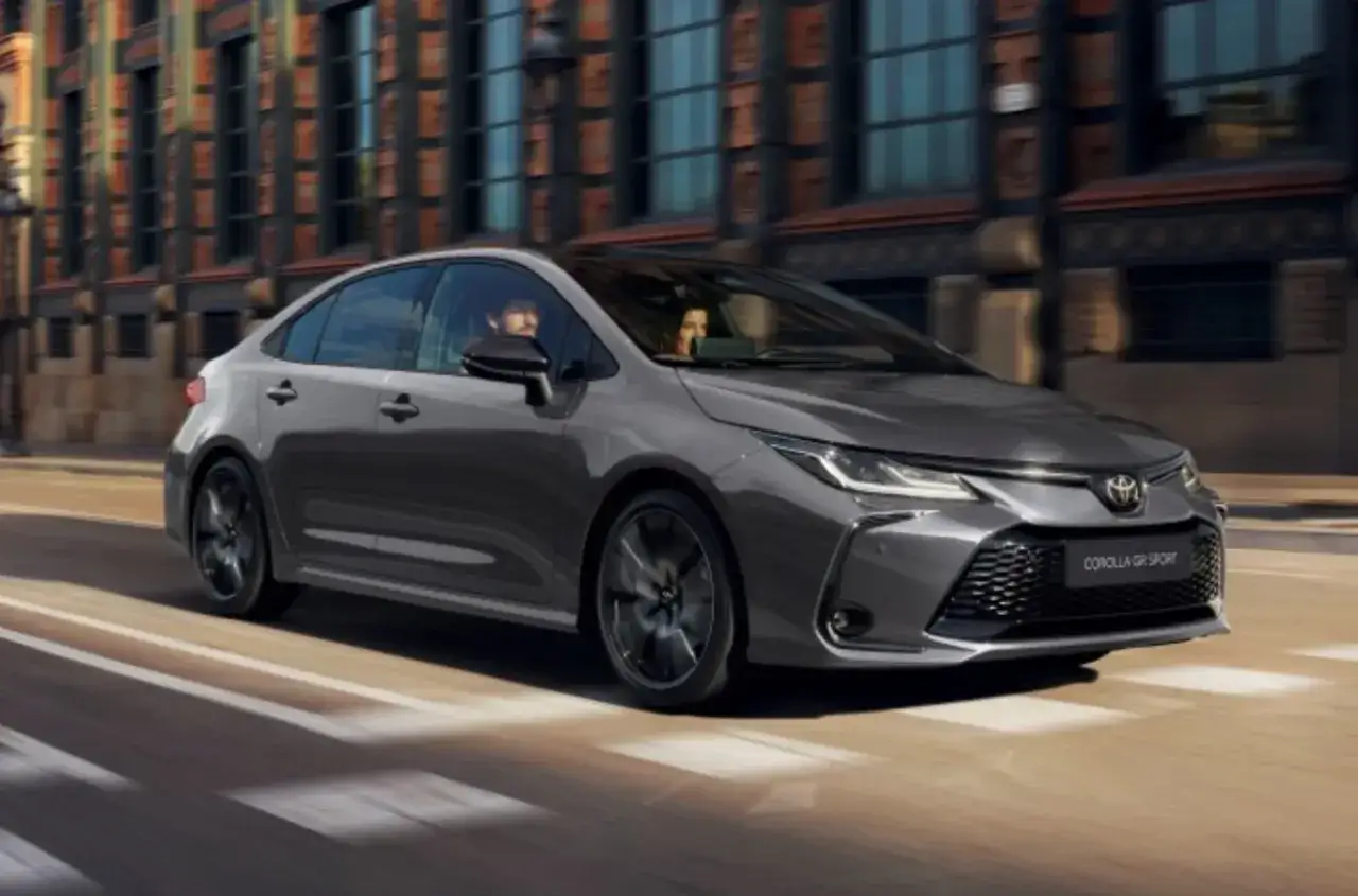 Elegancka, ciemnoszara Toyota Corolla GR Sport 2025 przemierza miejskie ulice.