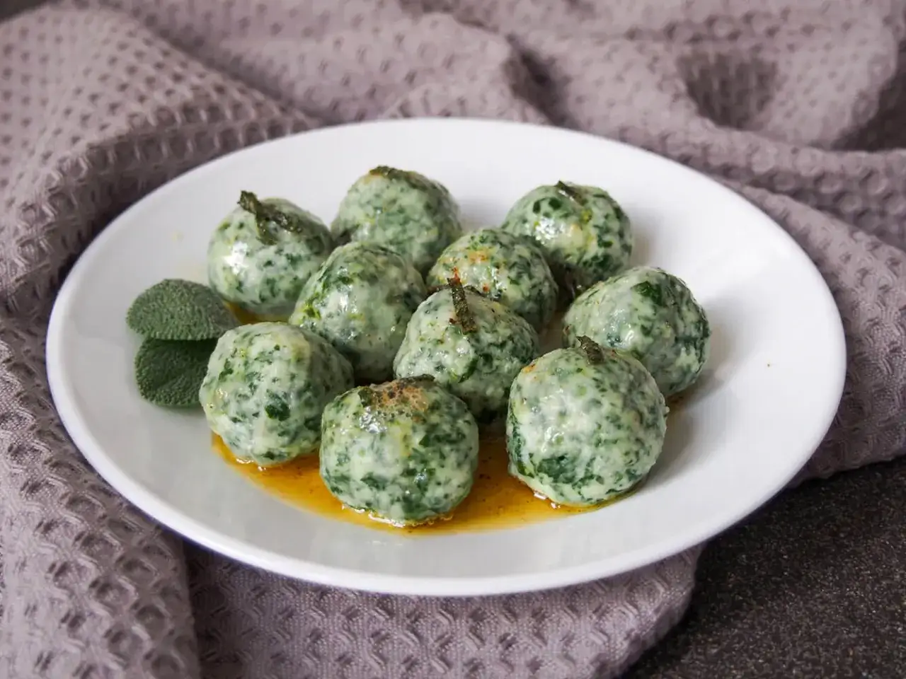 Malfatti: grüne Klößchen aus Spinat und Ricotta, serviert mit Salbeibutter. Was ist das? Ein Genuss!