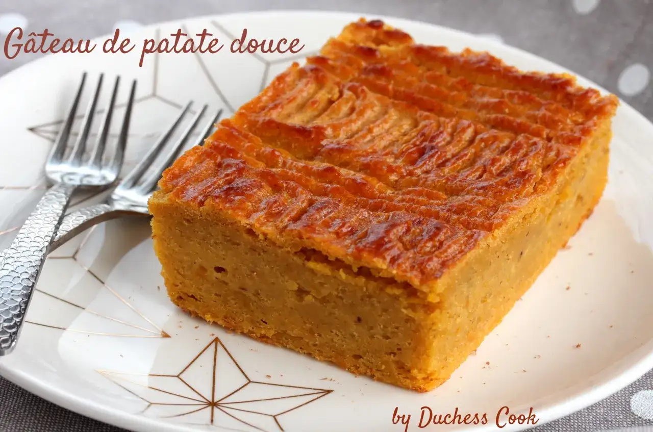 Un d&eacute;licieux g&acirc;teau de patate douce, dor&eacute; et moelleux, servi sur une assiette orn&eacute;e de motifs g&eacute;om&eacute;triques, avec deux fourchettes argent&eacute;es.