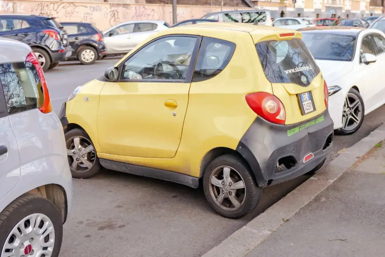 Żółty samochód elektryczny, idealny jako samochód bez prawa jazdy, zaparkowany na ulicy.
