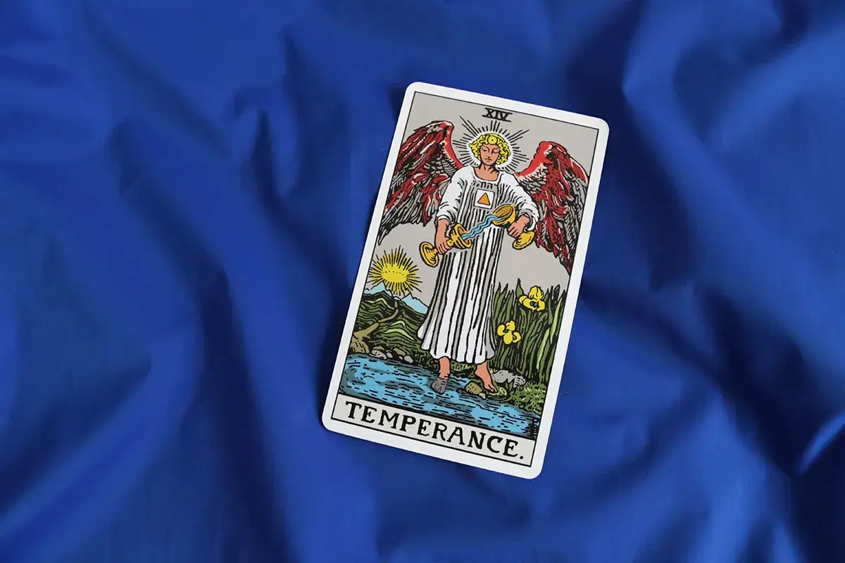 Karta Umiarkowanie z talii tarota, idealna na tarot na tydzień. Anioł przelewa wodę między dwoma kielichami.