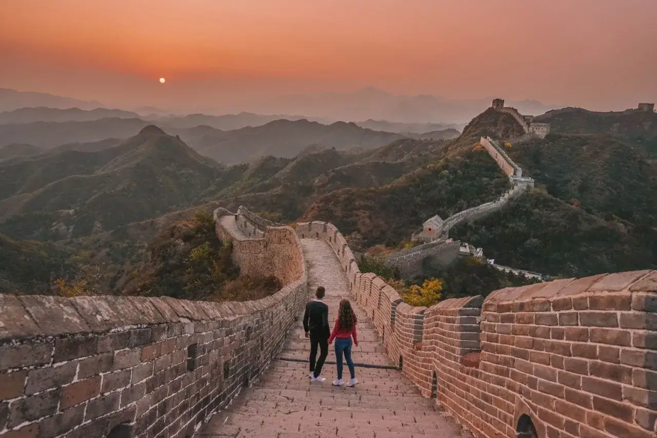 Pareja camina por la Gran Muralla China al atardecer. El oto&ntilde;o es la mejor &eacute;poca para viajar a China, con cielos despejados y paisajes espectaculares.