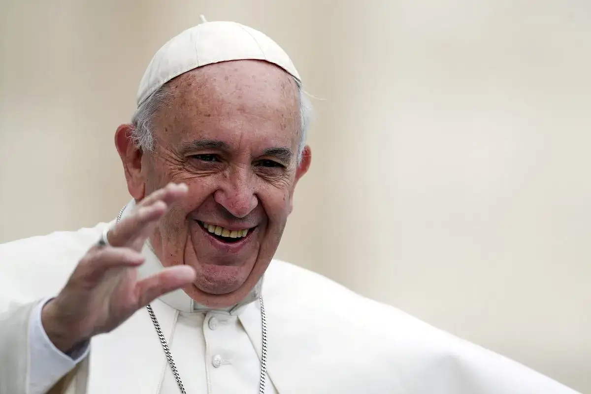 Uśmiechnięty Papież Franciszek pozdrawia. Wiele osób zastanawia się, ile lat ma papież, ale jego energia jest zaraźliwa.
