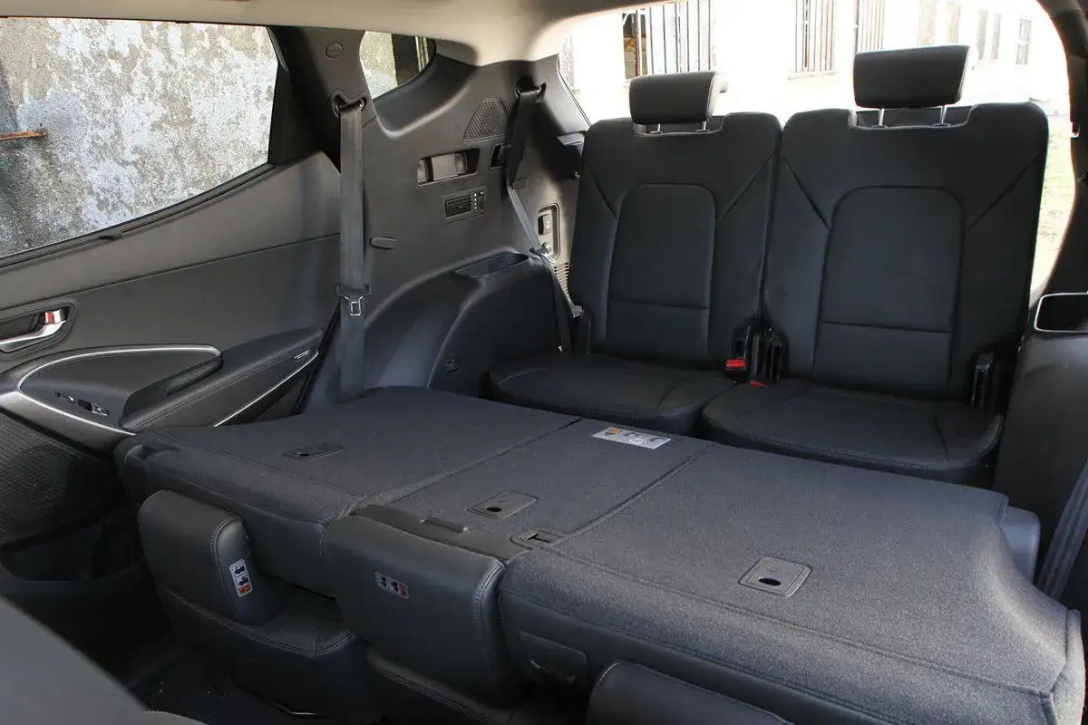 Asientos plegados en un monovolumen o SUV, creando un espacio de carga amplio y plano.