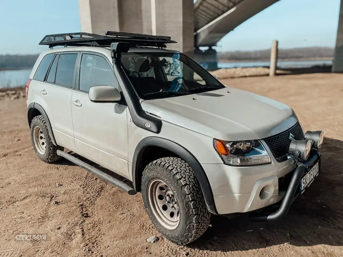 Suzuki Grand Vitara 1.9 ddis gotowy na off-road pod mostem. Wyciągnięty na piasek, z bagażnikiem dachowym i snorkel'em.