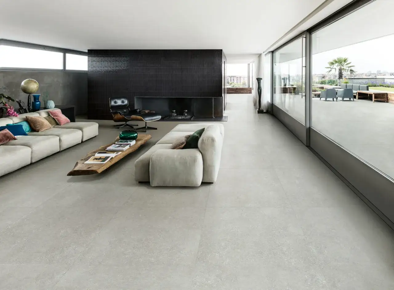 Modernes Wohnzimmer mit großem Sofa, Kamin und Glasfront. Der schlichte Raum verkörpert den 