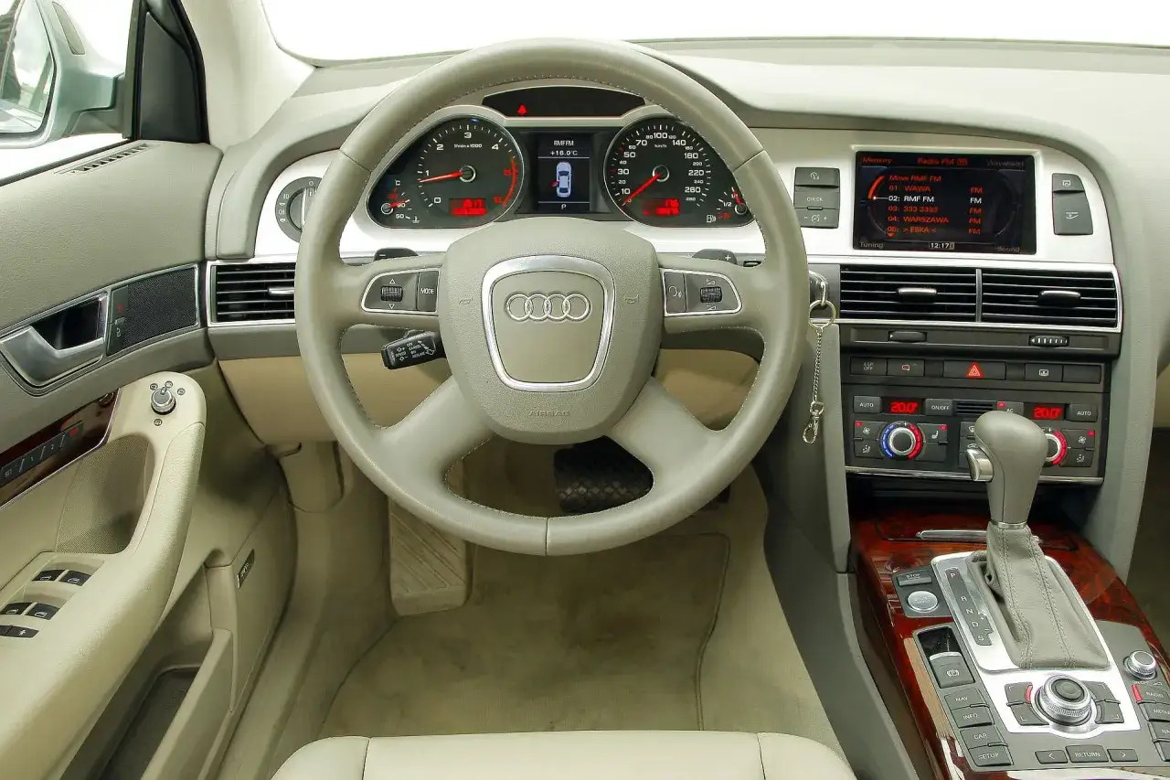Wnętrze Audi A6 C6, kierownica, deska rozdzielcza z radiem i klimatyzacją. Wiele osób szuka audi a6 c6 opinie, to wnętrze pokazuje komfort i wyposażenie.