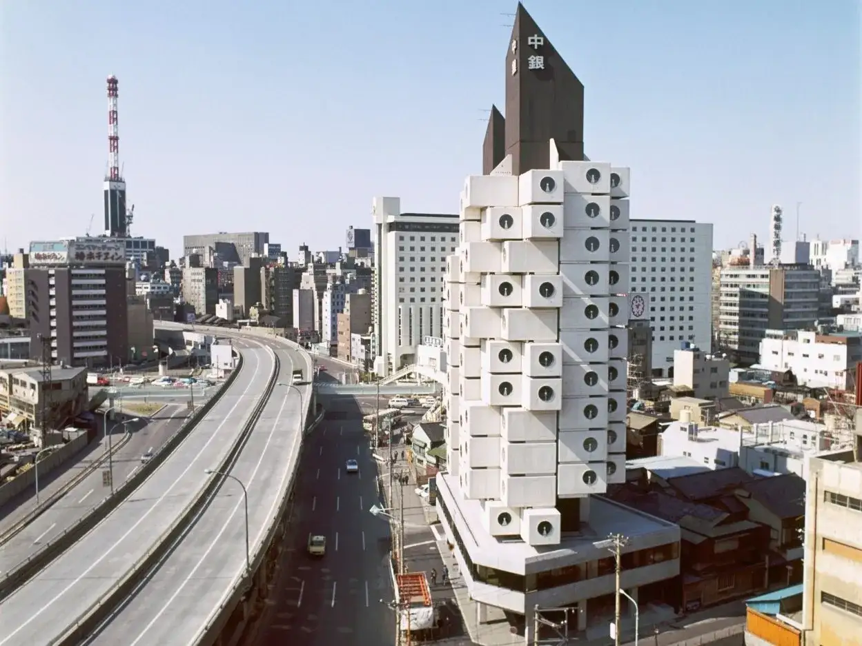 Iconico edificio Nakagin Capsule Tower, con le sue capsule modulari che si stagliano nel paesaggio urbano di Tokyo.