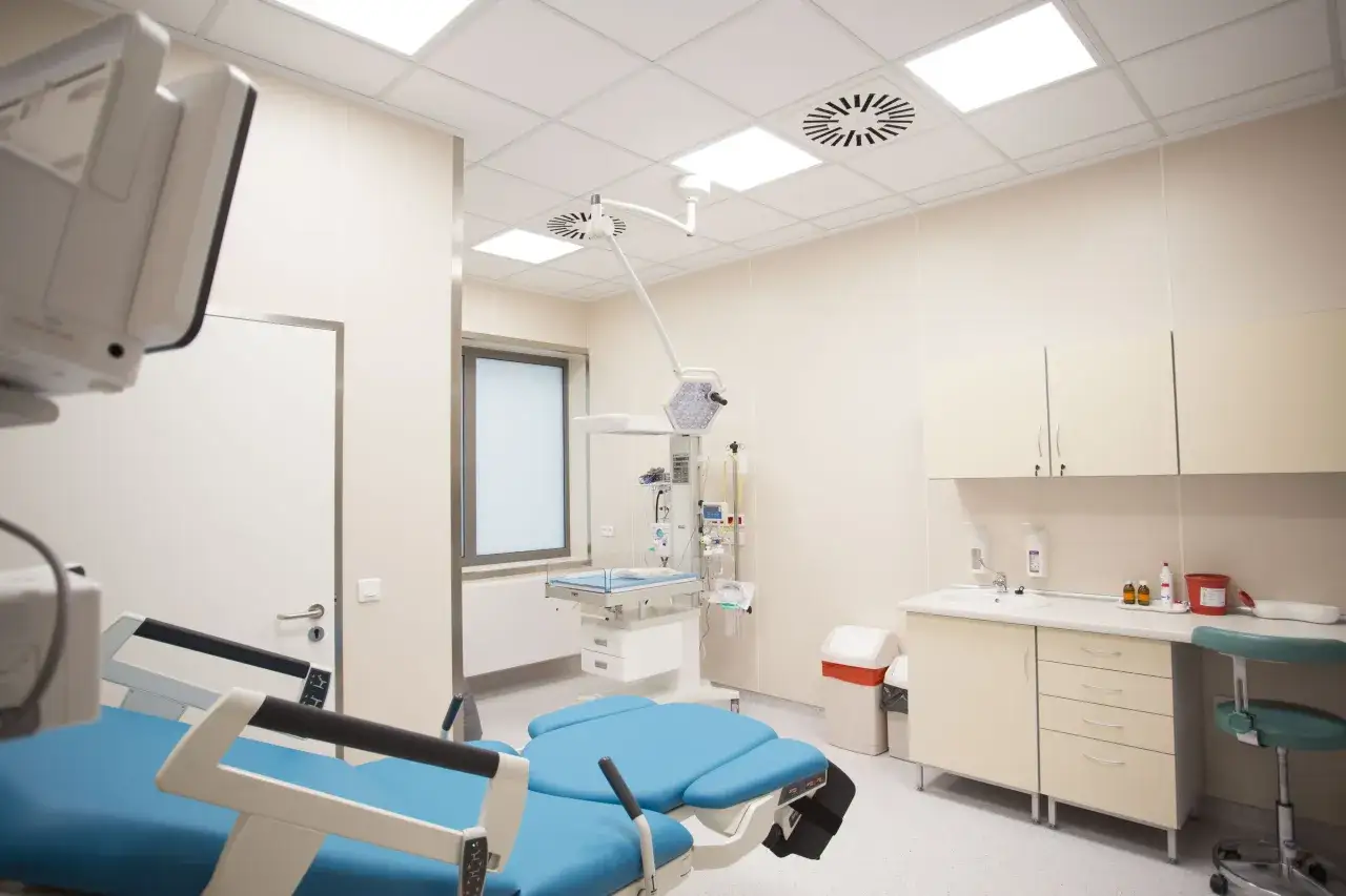 Sala porodowa w szpitalu Żwirki i Wigury. Nowoczesny sprzęt medyczny, łóżko porodowe i inkubator dla noworodka.