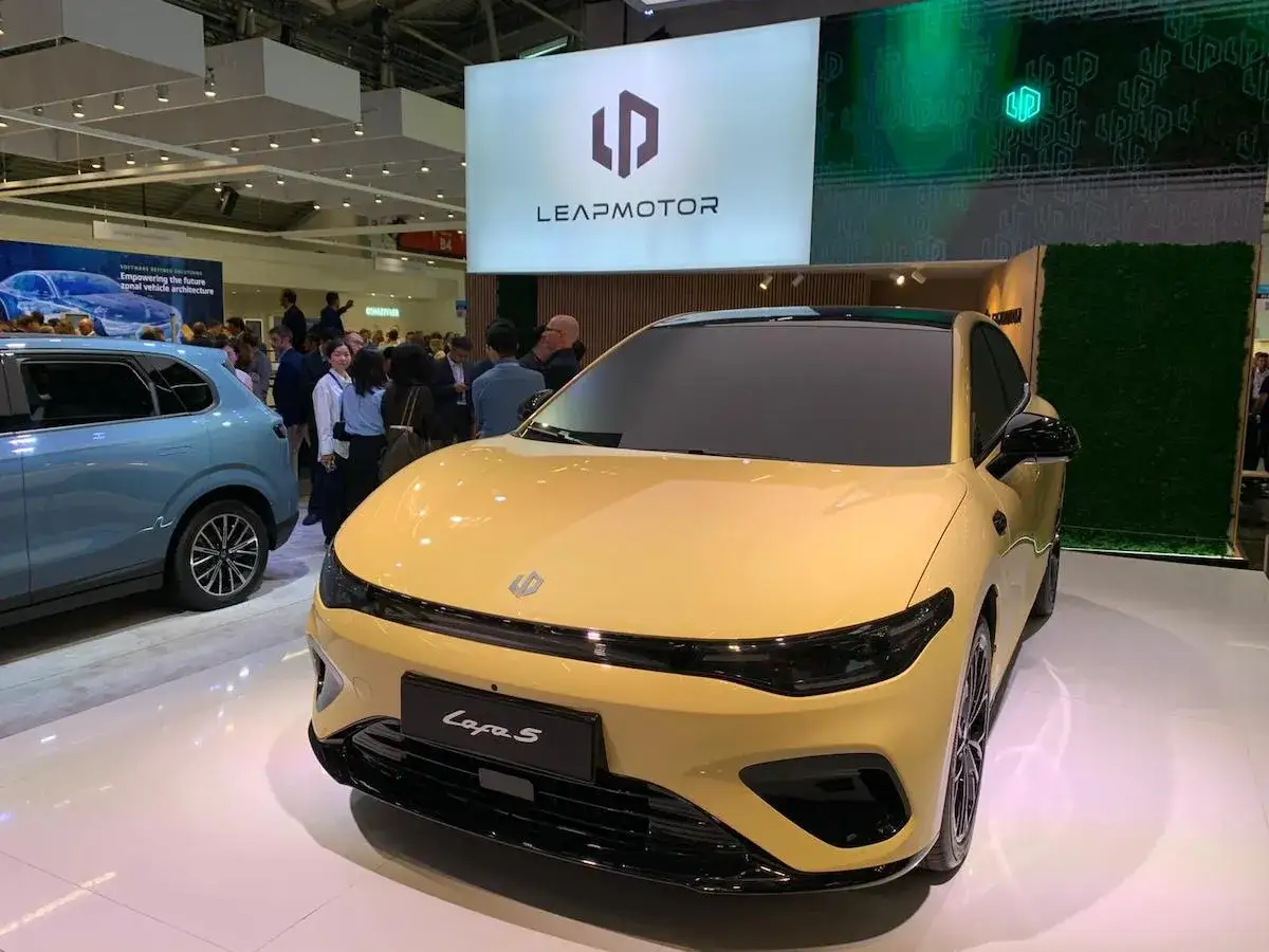 Auto Leapmotor C-A-S, un'elegante berlina gialla, in mostra con un SUV blu sullo sfondo.