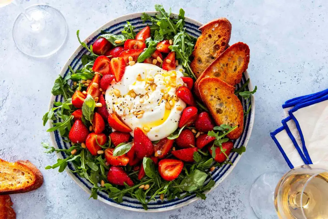 En krämig burrata med jordgubbar, ruccola och rostade krutonger. Ett perfekt burrata recept för en lätt lunch eller förrätt.