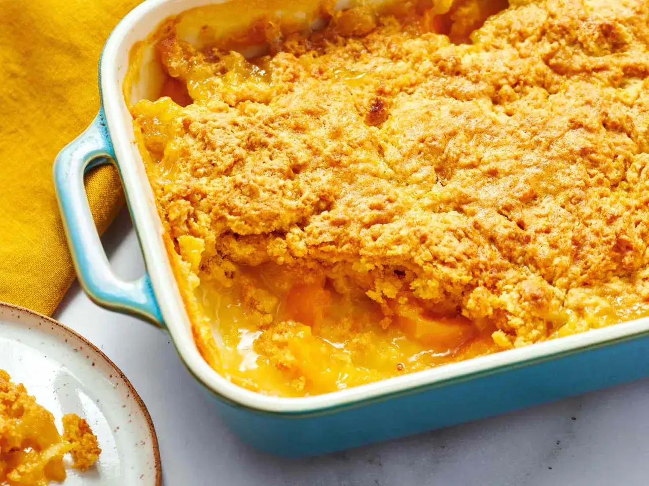 En gyllene crumble med frukt i en blå ugnsform. Perfekt för att baka enkelt och njuta av en hemlagad dessert.