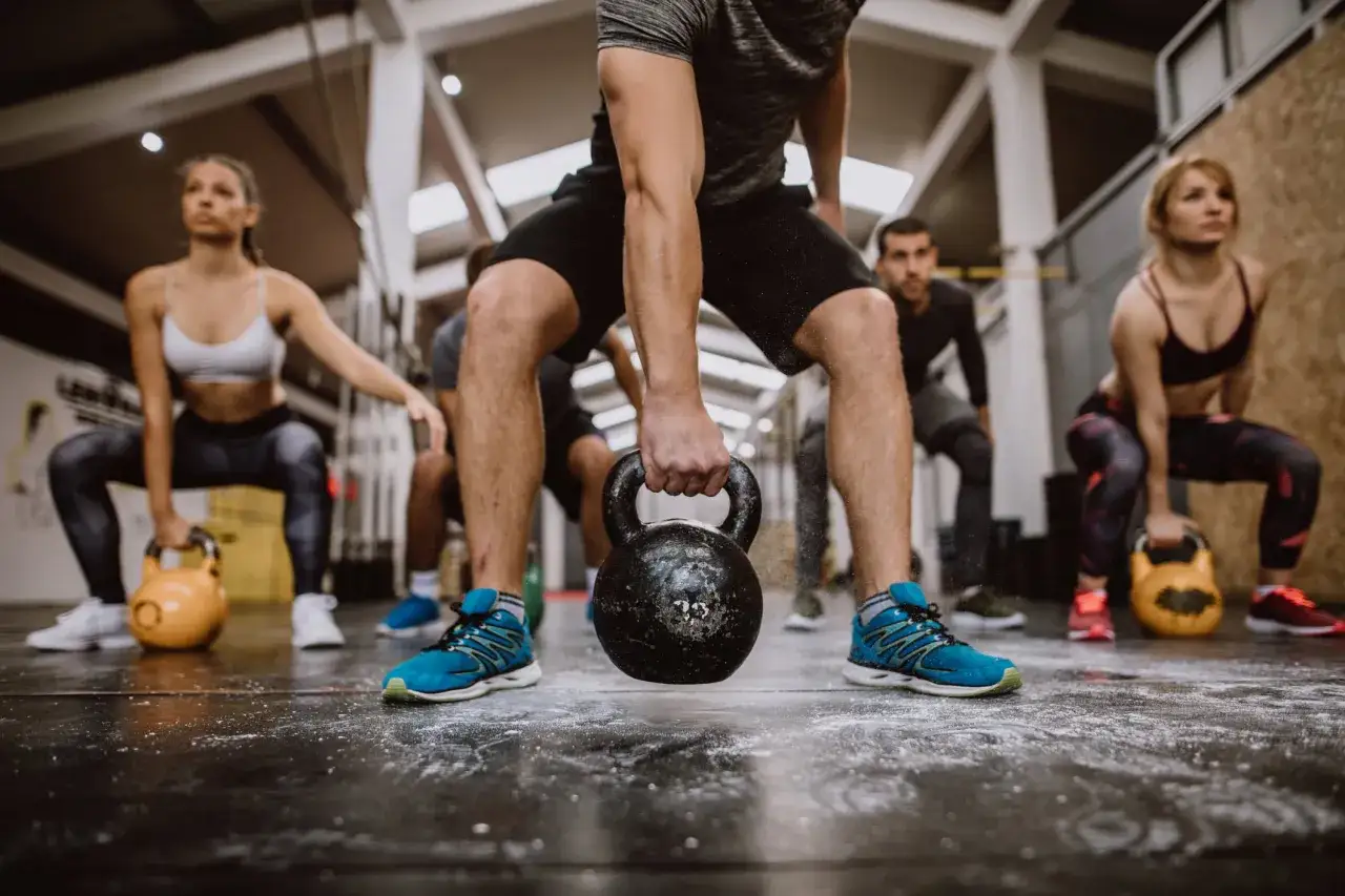 Ludzie ćwiczą z kettlebellami, czując energię jak po dawce kofeiny bezwodnej.