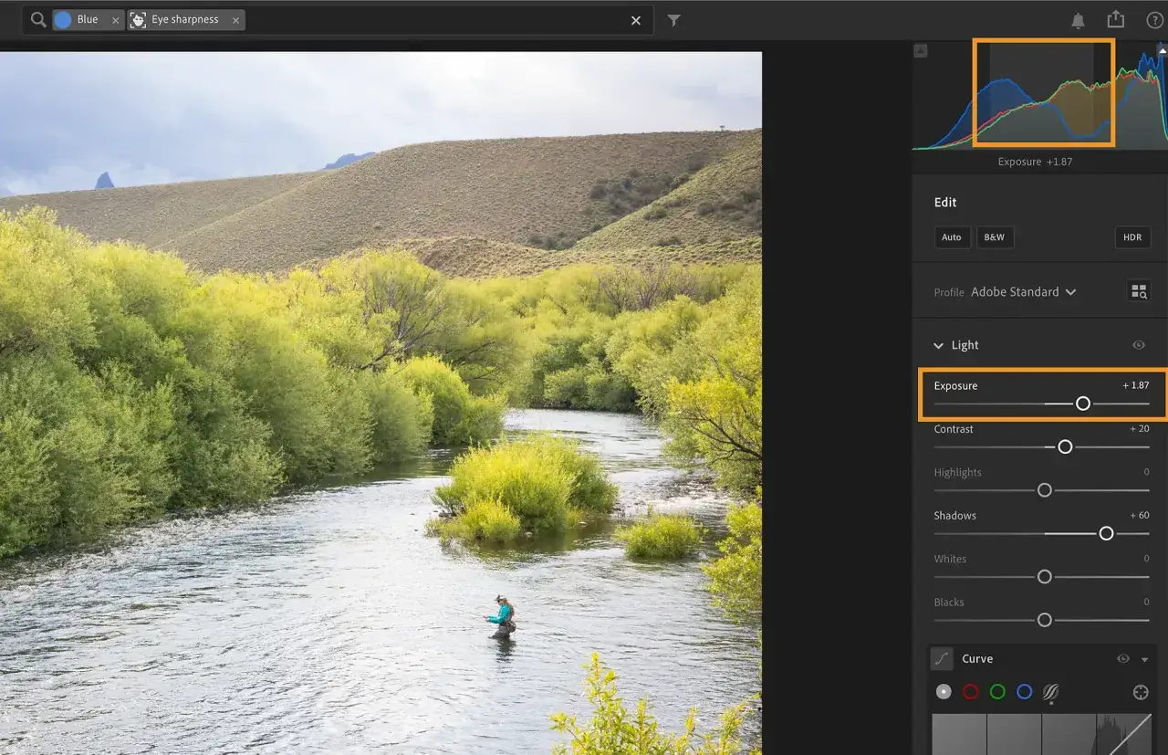 Lightroom poradnik: regulacja ekspozycji zdjęcia z wędkarzem w rzece. Widok panelu edycji z suwakiem ekspozycji.