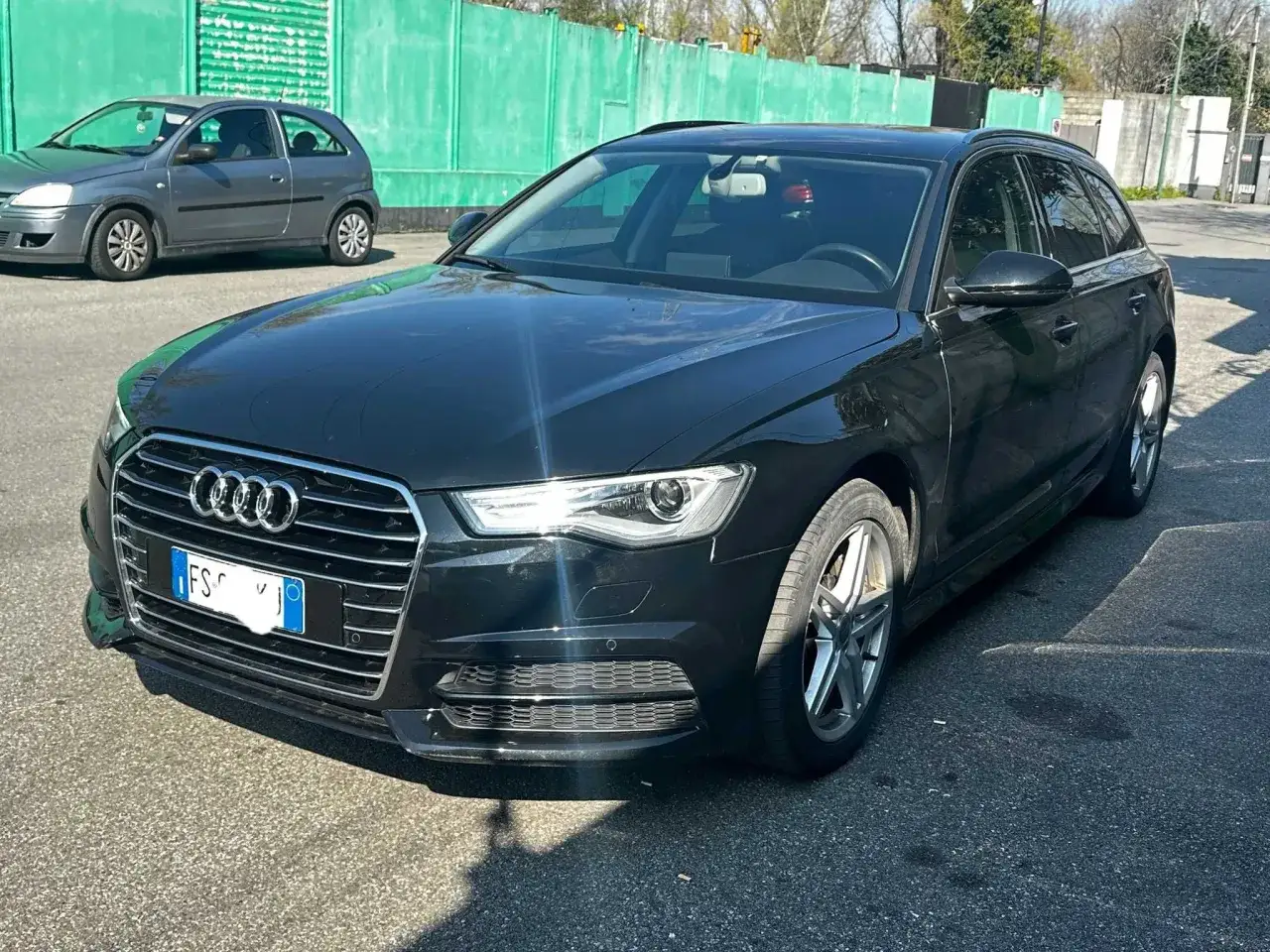 Czarny Audi kombi, idealny dla szukających tanie samochody do 3000 zł. Obok szary Opel Corsa.