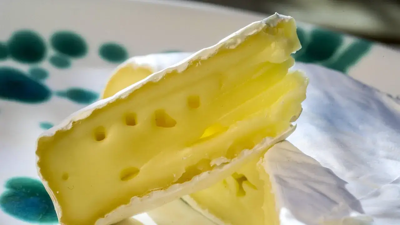 Ein St&uuml;ck cremiger Camembert mit Rinde, das an Schwangerschaftsgel&uuml;ste erinnert.