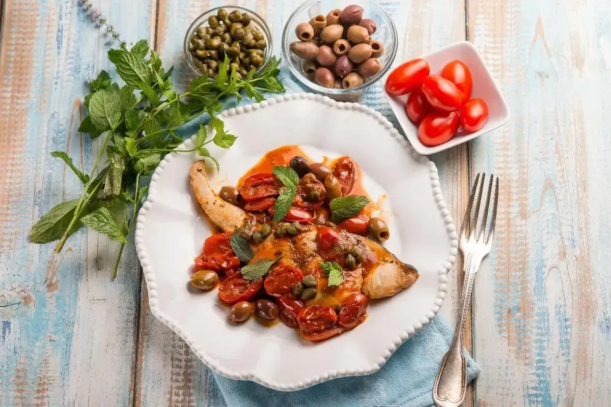 Piatto di pesce spada con pomodorini, olive e capperi, un'ottima ricetta pesce spada mediterranea.