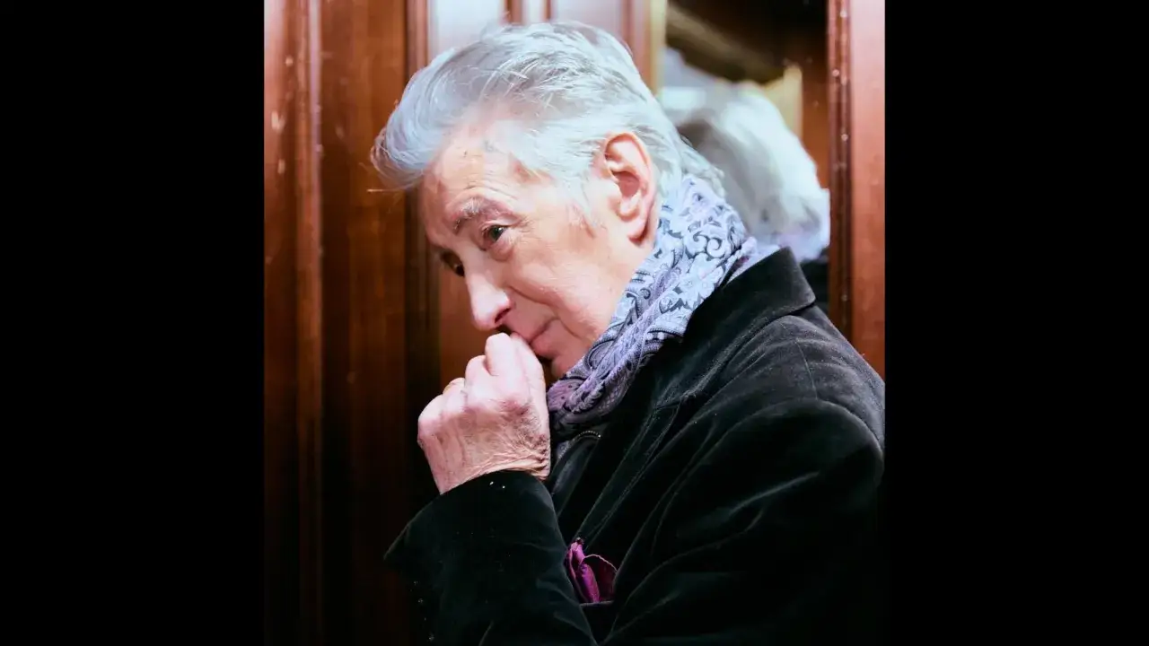 Tommy Berggren med gr&aring;tt h&aring;r och en m&ouml;nstrad scarf, funderar djupt.