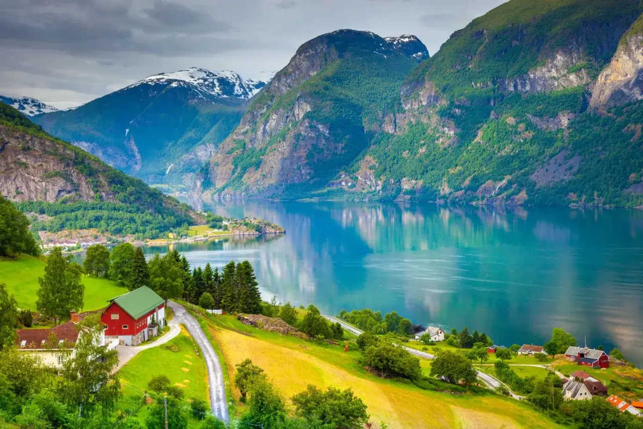 Malowniczy fiord z zielonymi wzgórzami i domkami, idealne miejsce, by zobaczyć, co zwiedzić w Bergen.