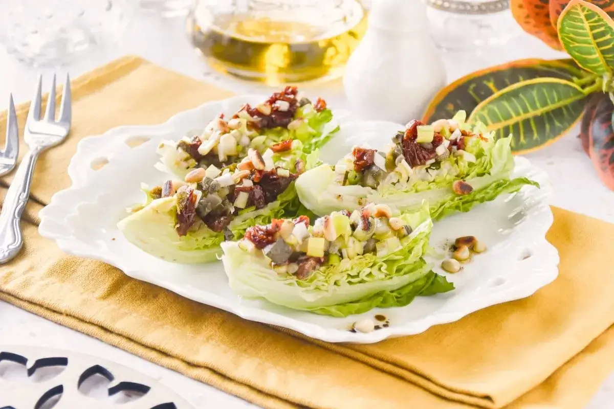Deliciosa ensalada de cogollos con trocitos de tomate seco, pi&ntilde;ones y aceitunas. Un bocado fresco y lleno de sabor.