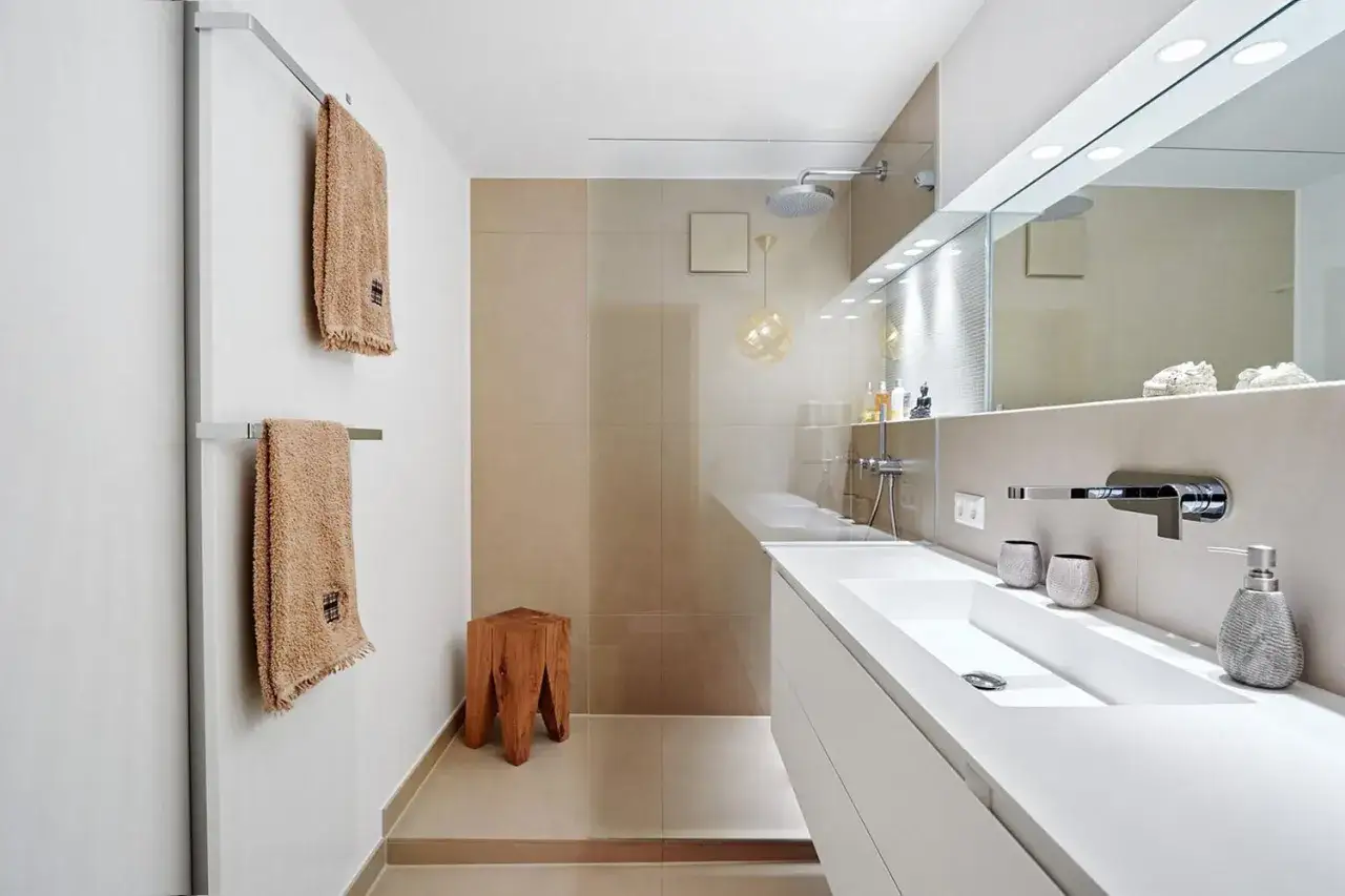 Bagno elegante piccolo con lavabo moderno, doccia a pioggia e dettagli in legno.