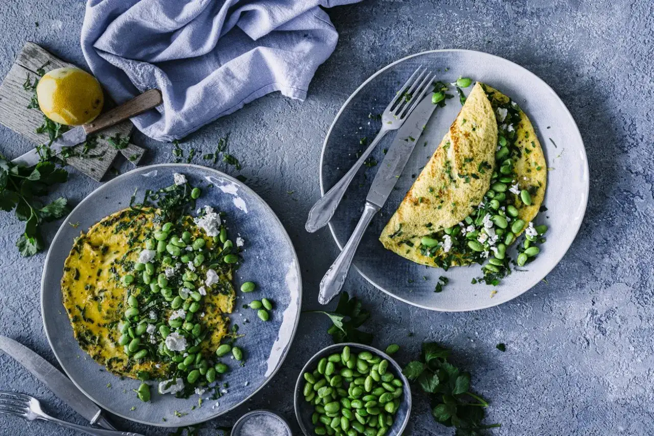Zwei k&ouml;stliche Omeletts mit Feta, Edamame und frischen Kr&auml;utern, bereit zum Genie&szlig;en.