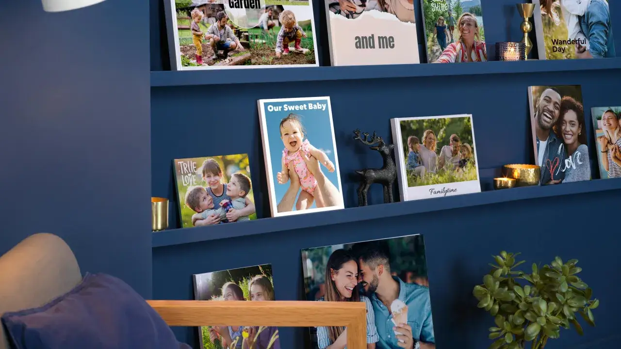 Schöne Fotowand Ideen mit Familienfotos auf blauen Regalen. Ein Baby, Kinder und Paare lächeln von den Bildern.