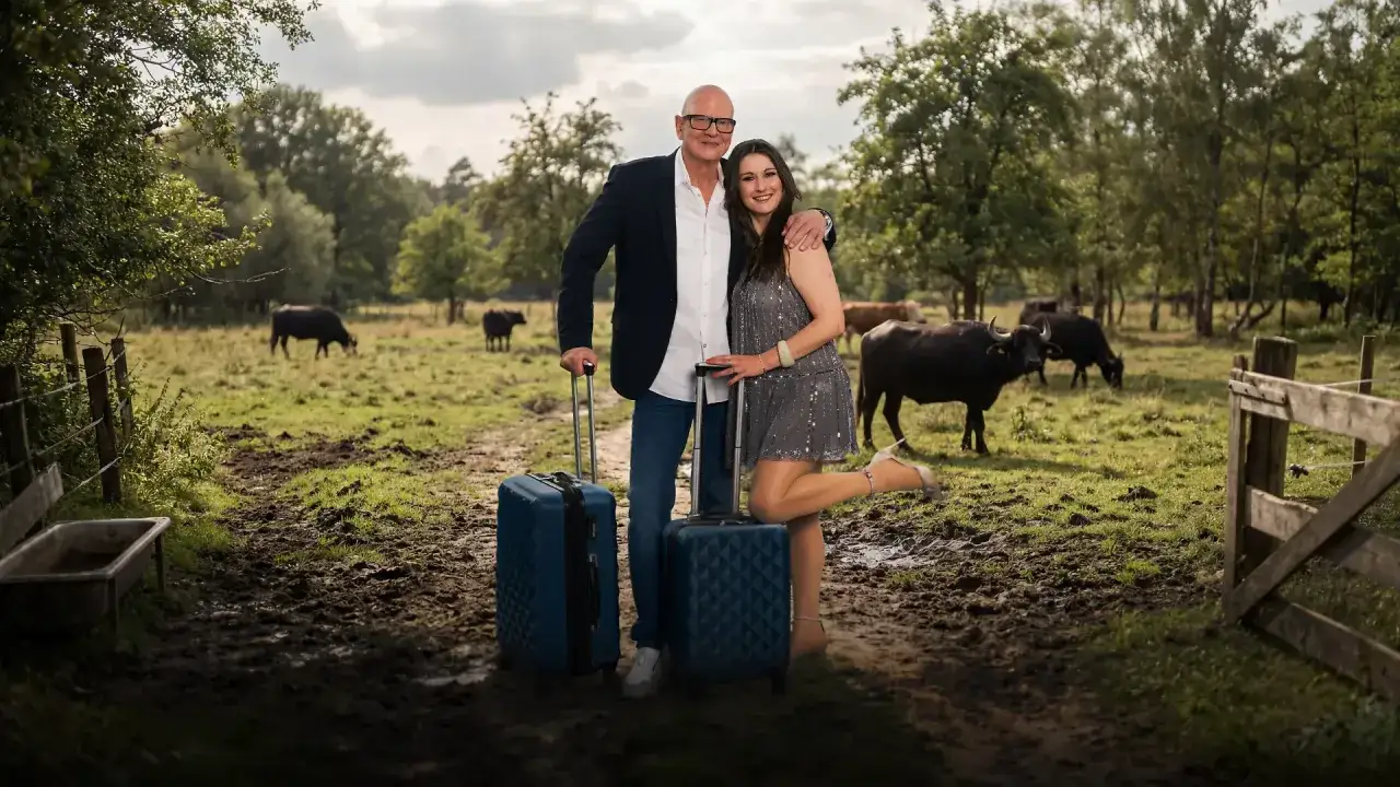 Ein Paar mit Koffern vor einer Herde B&uuml;ffel. Vielleicht ihr **Sommerhaus der Stars**?