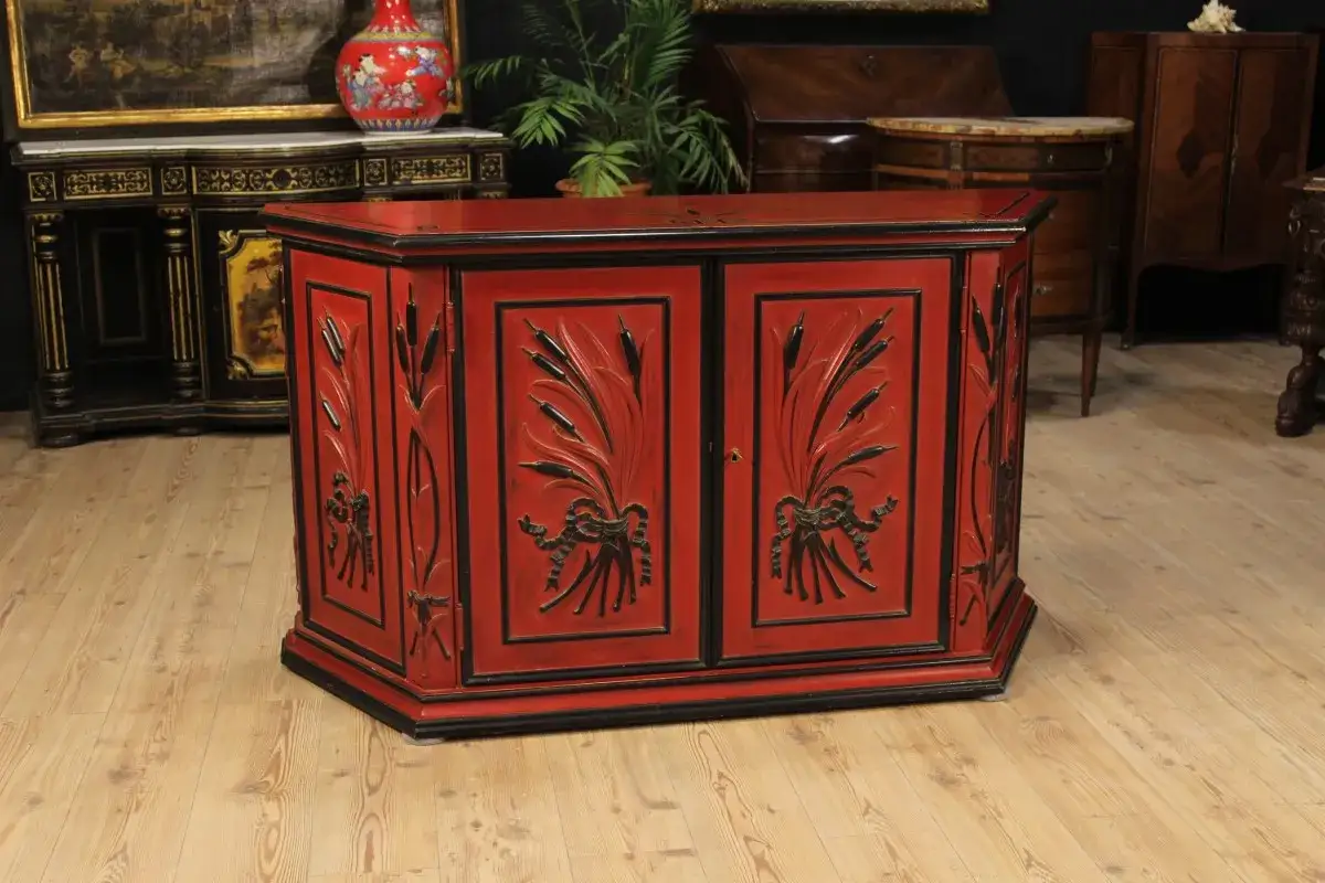 Mobile con laccatura rossa e decori neri a tema vegetale, un pezzo d'antiquariato che arreda con stile.